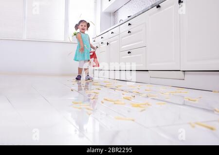 Lächelnde Mädchen werfen Pommes Frites In der Küche Stockfoto