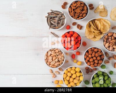 Sortiment von verschiedenen Snack für Bier, Wein, Party. Erdnüsse in Coconut Glasur, grüne vasabi, rote scharfe Chili, gelben Käse Glasur, Chips, Pistazie, Stockfoto