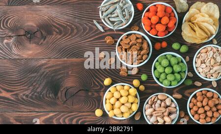 Sortiment von verschiedenen Snack für Bier, Wein, Party. Erdnüsse in Coconut Glasur, grüne vasabi, rote scharfe Chili, gelben Käse Glasur, Chips, Pistazie, Stockfoto