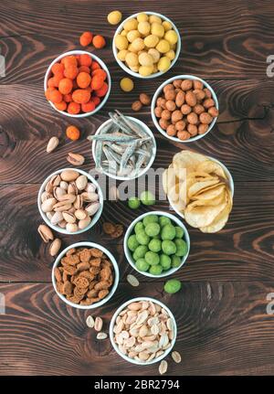 Sortiment von verschiedenen Snack für Bier, Wein, Party. Erdnüsse in Coconut Glasur, grüne vasabi, rote scharfe Chili, gelben Käse Glasur, Chips, Pistazie, Stockfoto