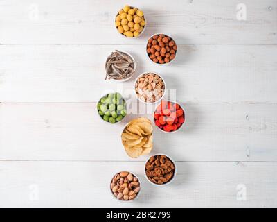 Sortiment von verschiedenen Snack für Bier, Wein, Party. Erdnüsse in Coconut Glasur, grüne vasabi, rote scharfe Chili, gelben Käse Glasur, Chips, Pistazie, Stockfoto