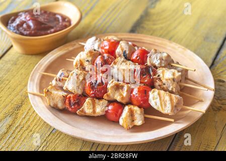 Gegrilltes Hähnchen und Cherry Tomaten Spieße auf der Platte Stockfoto