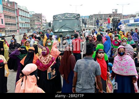 Dhaka, Bangladesch - 20. Mai 2020: Die Textilarbeiter aus Bangladesch blockieren eine Straße, während sie sich in einem Protest versammeln, der ihre unbezahlten Löhne während des ganzen Landes fordert Stockfoto
