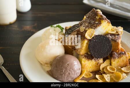 Sweet Toast Brot oder Nachspeise und Cookies und Schoko Vanille Eis und Cornflakes und Sahne und Schokolade Kakao Pulver. Dessert Toast br Stockfoto