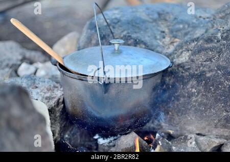Kochen in einem Kessel auf offenem Feuer. Zubereitung von Speisen im Sta Stockfoto