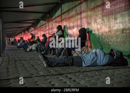 19. Mai 2020, Mexiko, Tijuana: Menschen schlafen im Morgengrauen auf dem Boden oder auf Campingstühlen vor dem Grenzübergang Otay mitten in der Pandemie von Corona. Da die US-Regierung beschlossen hat, die Öffnungszeiten des Grenzübergangs gegen die Ausbreitung des Corona-Virus zu begrenzen, Und der Übertritt ist erst um 6 Uhr morgens geöffnet, viele Pendler schlafen stundenlang vor dem Postweg auf der mexikanischen Seite der Grenze, um morgens pünktlich zur Arbeit zu kommen. Der Grenzübergang ist zwischen 10 und 6 Uhr geschlossen. Nur US-Bürger oder Personen mit einer US-Aufenthaltserlaubnis sind dann in die USA zugelassen. Foto: Stockfoto