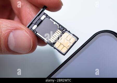 Nahaufnahme von einer Person Hand Einlegen der SIM-Karte im Handy Stockfoto