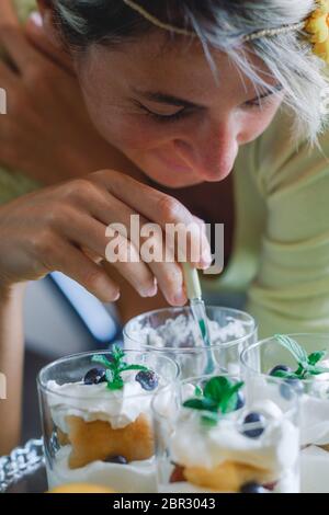 Erwachsene blonde Frau mit hausgemachten Dessert. Nahaufnahme Bild der jungen Dame essen Dessert. Stockfoto