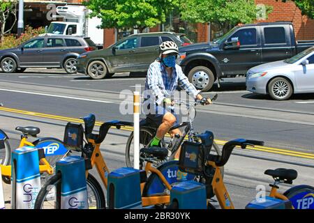Radfahrer mit einer Covid-19 Facemask während er in Tucson, AZ radelt Stockfoto