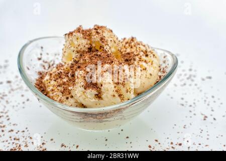 Glasschüssel mit Kugeln aus Vanille-Eis mit Schokoladenchips bestreut Stockfoto