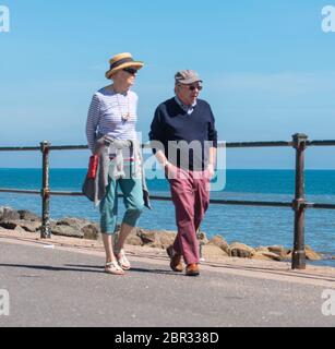 Ein Paar schlendern entlang der Esplanade in Sidmouth und genießen die heiße Sonne vor dem Feiertagswochenende. Quelle: DWR/Alamy Live News Stockfoto