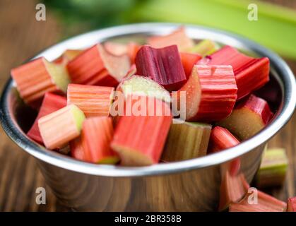 Gehackter Rhabarber auf einem alten Holztisch (Nahaufnahme; selektiver Fokus) Stockfoto