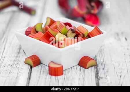 Gehackter Rhabarber auf einem alten Holztisch (Nahaufnahme; selektiver Fokus) Stockfoto