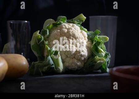 Weißer und grüner Blumenkohl auf einem Holztisch in einer rustikalen Küche. Veganes und vegetarisches Diätkonzept mit leerem Kopieplatz für den Inhalt der Redaktion. Stockfoto