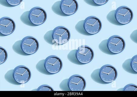 Trendiges Muster aus blauen Uhren auf pastellblauem Hintergrund. Stockfoto