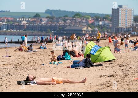 Portobello, Schottland, Großbritannien. 20 Mai 2020. Heißes sonniges Wetter brachte heute große Menschenmengen zum Strand von Portobello. Lockdown Disziplin scheint eine Sache der Vergangenheit mit Familien und Freunden schlagen den Sand. Eine schwerere als normale Polizeipräsenz hatte kaum sichtbare Wirkung, da die Öffentlichkeit nach dem Gehen der Polizei wieder in den Sand zurückkehrte. Iain Masterton/Alamy Live News Stockfoto