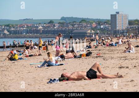 Portobello, Schottland, Großbritannien. 20 Mai 2020. Heißes sonniges Wetter brachte heute große Menschenmengen zum Strand von Portobello. Lockdown Disziplin scheint eine Sache der Vergangenheit mit Familien und Freunden schlagen den Sand. Eine schwerere als normale Polizeipräsenz hatte kaum sichtbare Wirkung, da die Öffentlichkeit nach dem Gehen der Polizei wieder in den Sand zurückkehrte. Iain Masterton/Alamy Live News Stockfoto