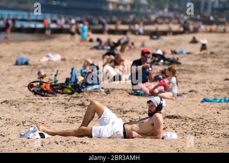 Portobello, Schottland, Großbritannien. 20 Mai 2020. Heißes sonniges Wetter brachte heute große Menschenmengen zum Strand von Portobello. Lockdown Disziplin scheint eine Sache der Vergangenheit mit Familien und Freunden schlagen den Sand. Eine schwerere als normale Polizeipräsenz hatte kaum sichtbare Wirkung, da die Öffentlichkeit nach dem Gehen der Polizei wieder in den Sand zurückkehrte. Iain Masterton/Alamy Live News Stockfoto
