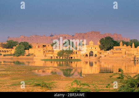 Historisches Tor am Ufer des Gadi Sagar Lake mit Jaisalmer Fort im Hintergrund, Jaisalmer, Rajasthan, Indien Stockfoto
