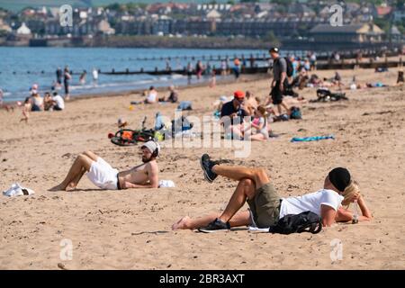 Portobello, Schottland, Großbritannien. 20 Mai 2020. Heißes sonniges Wetter brachte heute große Menschenmengen zum Strand von Portobello. Lockdown Disziplin scheint eine Sache der Vergangenheit mit Familien und Freunden schlagen den Sand. Eine schwerere als normale Polizeipräsenz hatte kaum sichtbare Wirkung, da die Öffentlichkeit nach dem Gehen der Polizei wieder in den Sand zurückkehrte. Iain Masterton/Alamy Live News Stockfoto