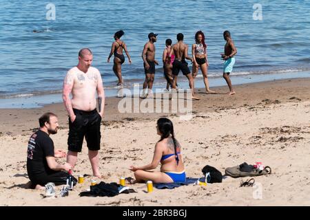 Portobello, Schottland, Großbritannien. 20 Mai 2020. Heißes sonniges Wetter brachte heute große Menschenmengen zum Strand von Portobello. Lockdown Disziplin scheint eine Sache der Vergangenheit mit Familien und Freunden schlagen den Sand. Eine schwerere als normale Polizeipräsenz hatte kaum sichtbare Wirkung, da die Öffentlichkeit nach dem Gehen der Polizei wieder in den Sand zurückkehrte. Iain Masterton/Alamy Live News Stockfoto
