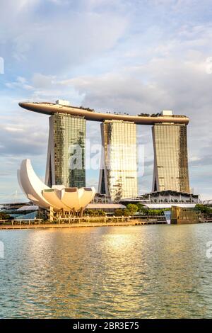 SINGAPUR - 6. SEPTEMBER 2017: Goldene Reflexionen über das Marina Bay Sands Hotel und das ArtScience Museum an der Bucht von Singapur am späten Nachmittag Stockfoto