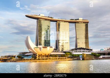 SINGAPUR - 6. SEPTEMBER 2017: Goldene Reflexionen über das Marina Bay Sands Hotel und das ArtScience Museum an der Bucht von Singapur am späten Nachmittag Stockfoto