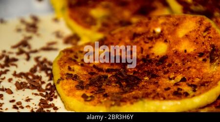 Käsekuchen mit saurer Sahne und Schokolade Chips auf einer Platte. Stockfoto