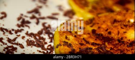 Käsekuchen mit saurer Sahne und Schokolade Chips auf einer Platte. Stockfoto