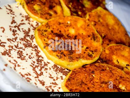 Käsekuchen mit saurer Sahne und Schokolade Chips auf einer Platte. Stockfoto