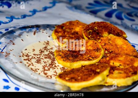 Käsekuchen mit saurer Sahne und Schokolade Chips auf einer Platte. Stockfoto