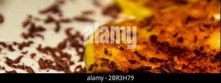 Käsekuchen mit saurer Sahne und Schokolade Chips auf einer Platte. Stockfoto