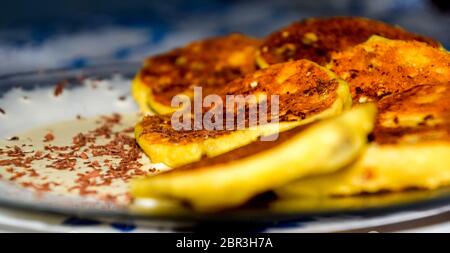 Käsekuchen mit saurer Sahne und Schokolade Chips auf einer Platte. Stockfoto