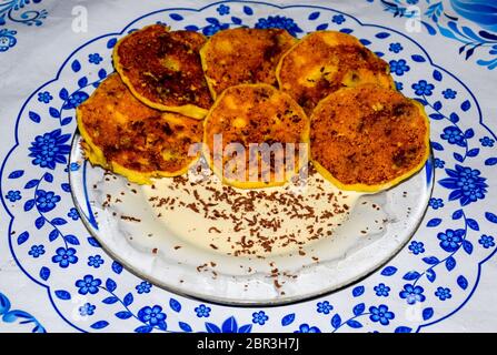 Käsekuchen mit saurer Sahne und Schokolade Chips auf einer Platte. Stockfoto