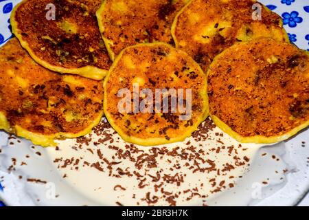 Käsekuchen mit saurer Sahne und Schokolade Chips auf einer Platte. Stockfoto