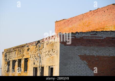 Alte sowjetische Brick verlassene Gebäude. Einstürzende gemauerte Konstruktion. weißen und roten Backstein Stockfoto