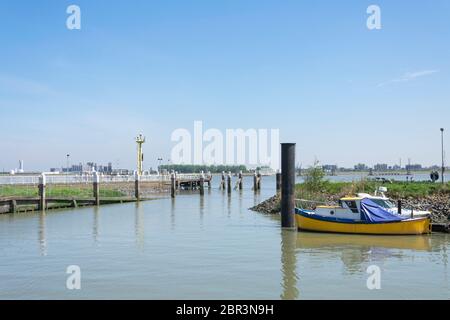 Blau-gelbes Boot rubbt bei Flut in der Marina von Doel Stockfoto