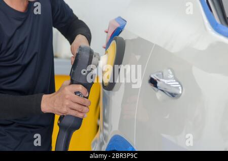 Mann bei der Arbeit Zum polieren, beschichten Autos. Stockfoto