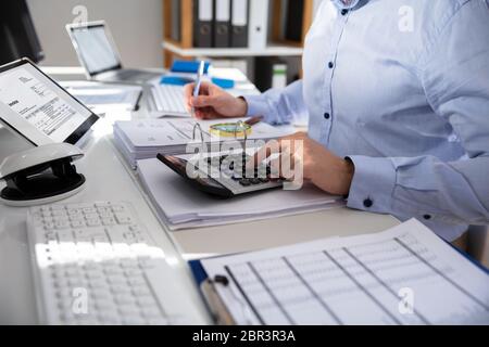 Unternehmer Berechnung Rechnung mit Rechner am Schreibtisch Stockfoto
