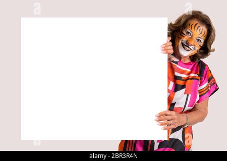 Ältere Frau mit Tiger face-Farbe über eine weiße Tafel in Weiß isoliert Stockfoto