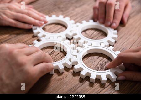 Gruppe von Geschäftsleuten zusammen Gänge verbinden auf Holztisch am Arbeitsplatz Stockfoto