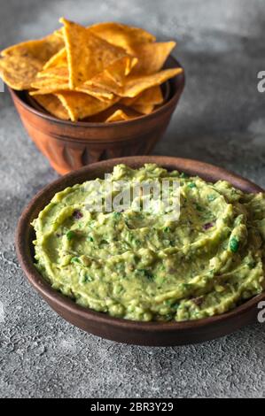 Guacamole in Schüssel mit Tortilla Chips Stockfoto