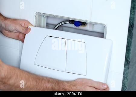 Klempner repariert ein Wasserventil in der Toilette Stockfoto