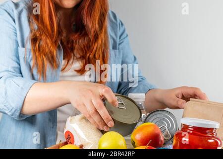 Volunteer sammelt verschiedene Produkte in einer Spendenbox. Stockfoto