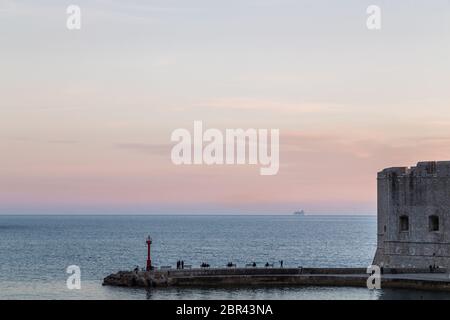 Touristen, die ein Kreuzfahrtschiff beobachten, verlassen Dubrovnik im Mai 2017 vom Rand des Hafens. Stockfoto