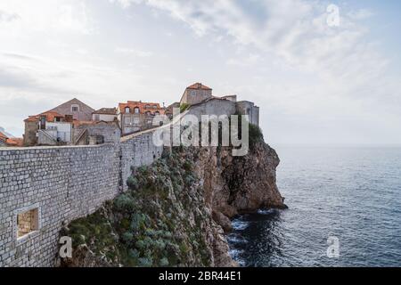 Dubrovnik Stadtmauern ragen in die Adria über felsigen Klippen. Stockfoto