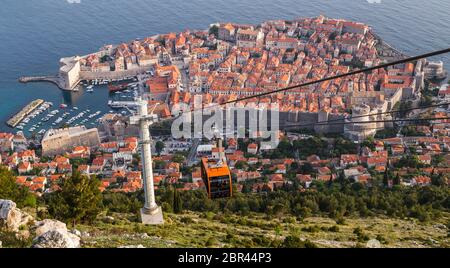 Die Seilbahn kommt von Dubrovnik an einem Abend im Mai 2017 und bringt Touristen zum Berg SRD für einen Panoramablick. Stockfoto