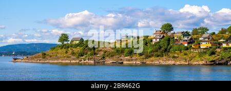 Oslo, Ostlandet / Norwegen - 2019/09/02: Panoramablick auf die Insel Lindoya am Oslofjord Hafen mit Sommerhäusern am Ufer im Frühherbst Stockfoto