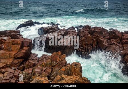 Stürmischen Meer Wellen gegen einen felsigen Ufer. Wellen, die über Felsen. Malerische Seenlandschaft. Stockfoto