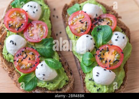 Sandwiches mit Avocado einfügen, Cherry Tomaten und Mozzarella Stockfoto